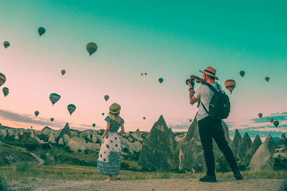 Two US expat travelers photographing hot air balloons