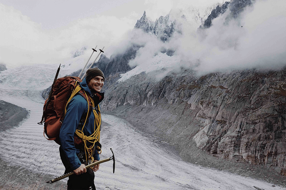 Digital nomad backpacker hiking next to mountain stream