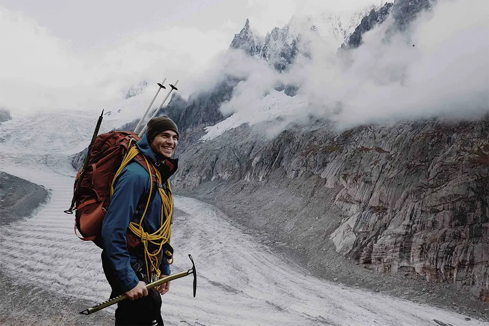 Digital nomad backpacker hiking next to mountain stream