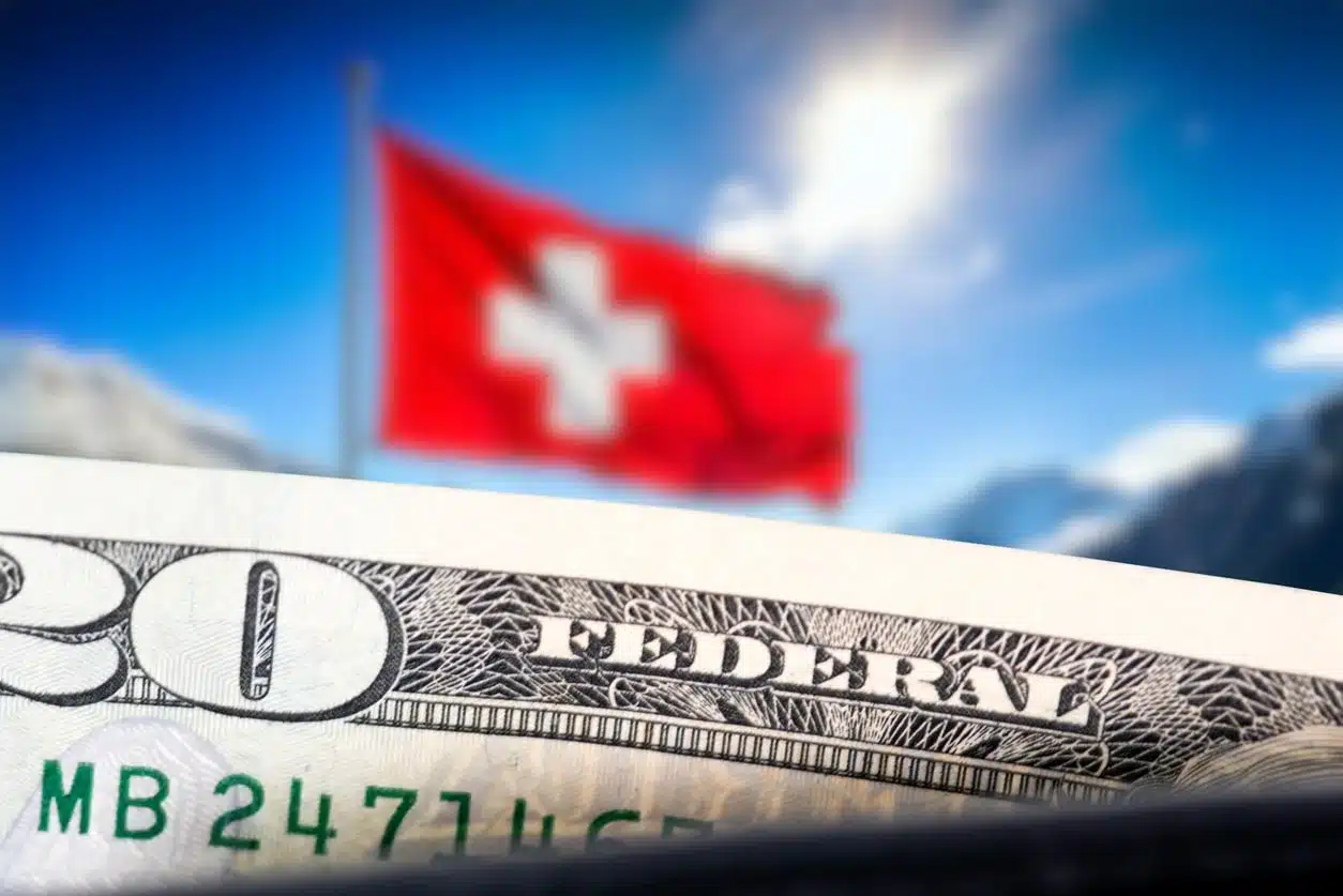 Close-up of a U.S. twenty-dollar bill with the Swiss flag waving against an alpine backdrop, representing cross-border banking for Americans in Switzerland.