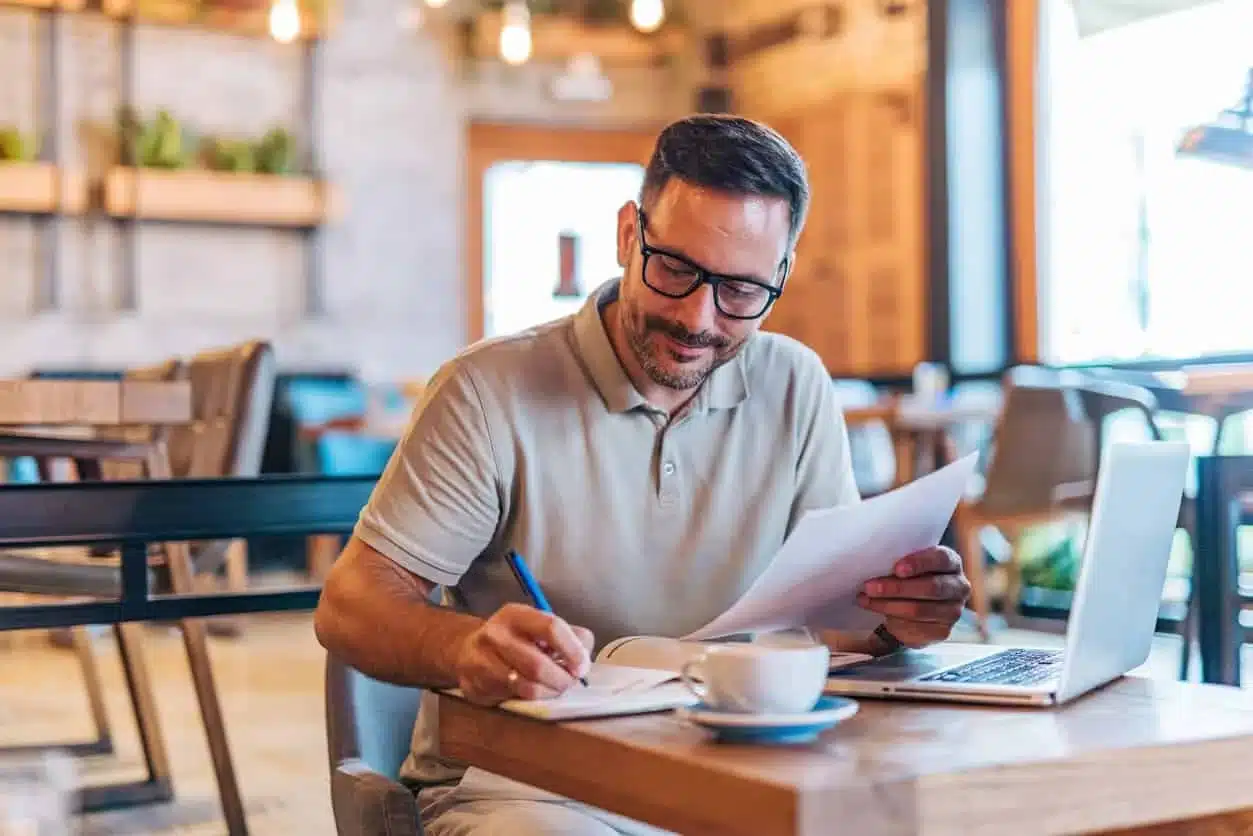 A mid adult man Working in a Café with a Cup of Coffee